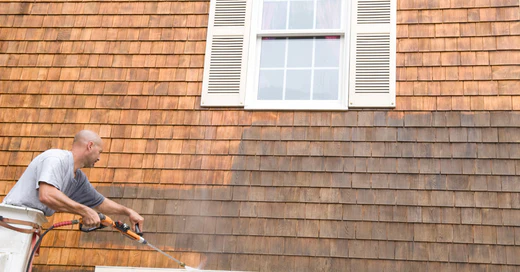 pressure washing exterior of home with shutters